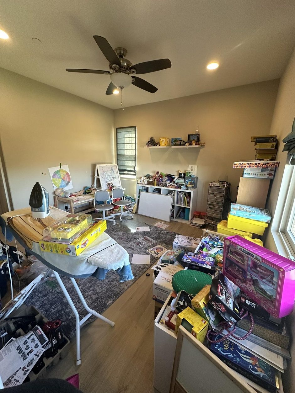 The playroom before: toys, boxes and an ironing board covering the rug and every surface